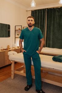 Masaż leczniczy Kraków – fizjoterapeuta Vladyslav Strutynskyi pracuje manualnie na plecach pacjentki w ERCGAMMA.